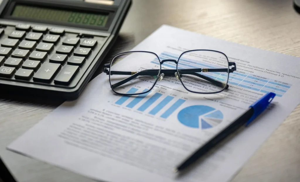 Calculator, glasses and a financial report on a desk